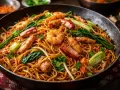 En stor panna med gyllene chow mein-nudlar, toppad med saftiga räkor, mört fläsk och krispiga grönsaker.