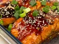 Saftiga filéer av asiatisk lax, glaserade med en mörk sås, toppade med sesamfrön och färsk salladslök.