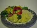 Enkel currysås över kyckling med ris och en fräsch sallad av paprika, gurka och tomat.
