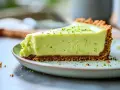 En krämig lime cheesecake med krispig botten, toppad med rivet limeskal. En perfekt dessert för en solig dag.