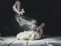 Händer strör mjöl över deg. En berättelse om svenskt bröd och kärleken till bakning med bra **bread flour svenska**.