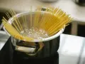 Spaghetti kokas i en kastrull på spisen. En perfekt mängd, för att veta hur mycket pasta per person som behövs.