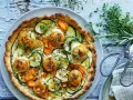 En gyllene, smakrik vegetarisk paj fylld med zucchini, morötter och toppad med ost. Garnerad med färska örter.