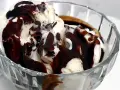 Vaniljglass i en skål med mörk chokladsås som stelnar och bildar härliga bitar.