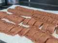 Rader av nybakade, sega chokladsnittar ligger på ett bakplåtspapper, redo att avnjutas.