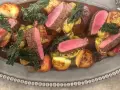 Vildsvinskött med perfekt rosa temperatur, serverat med rostade potatisar, brysselkål och grönkål i en mustig sås.
