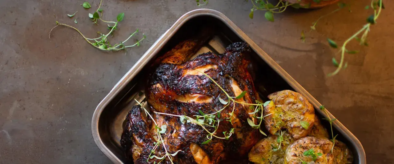 Helstekt kyckling med krispiga potatisar i ugnsform. Perfekt kyckling temperatur ger en saftig och god måltid.