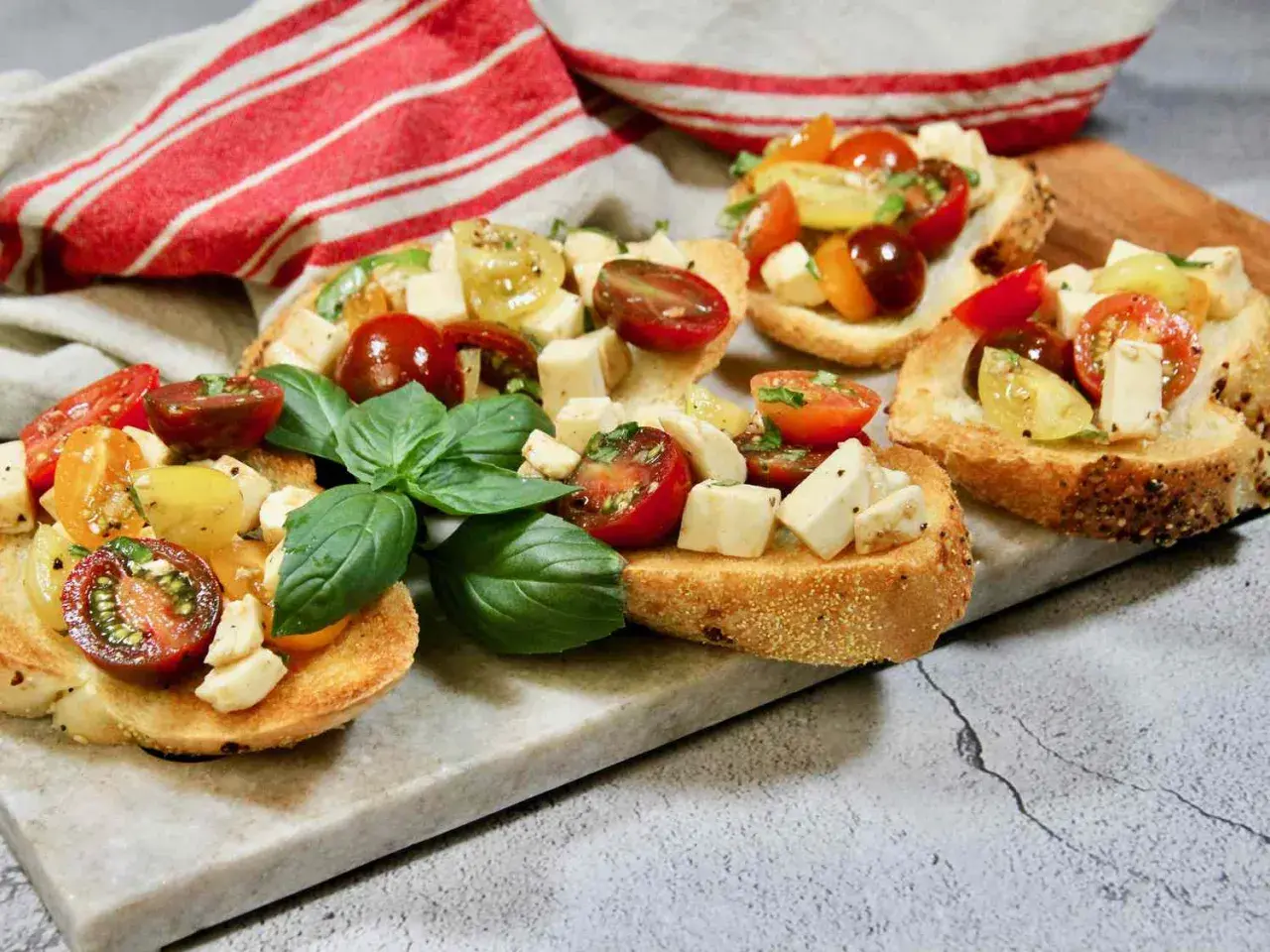 Bruschetta med mozzarella, färska tomater och basilika på rostat bröd. En härlig sommardelikatess.