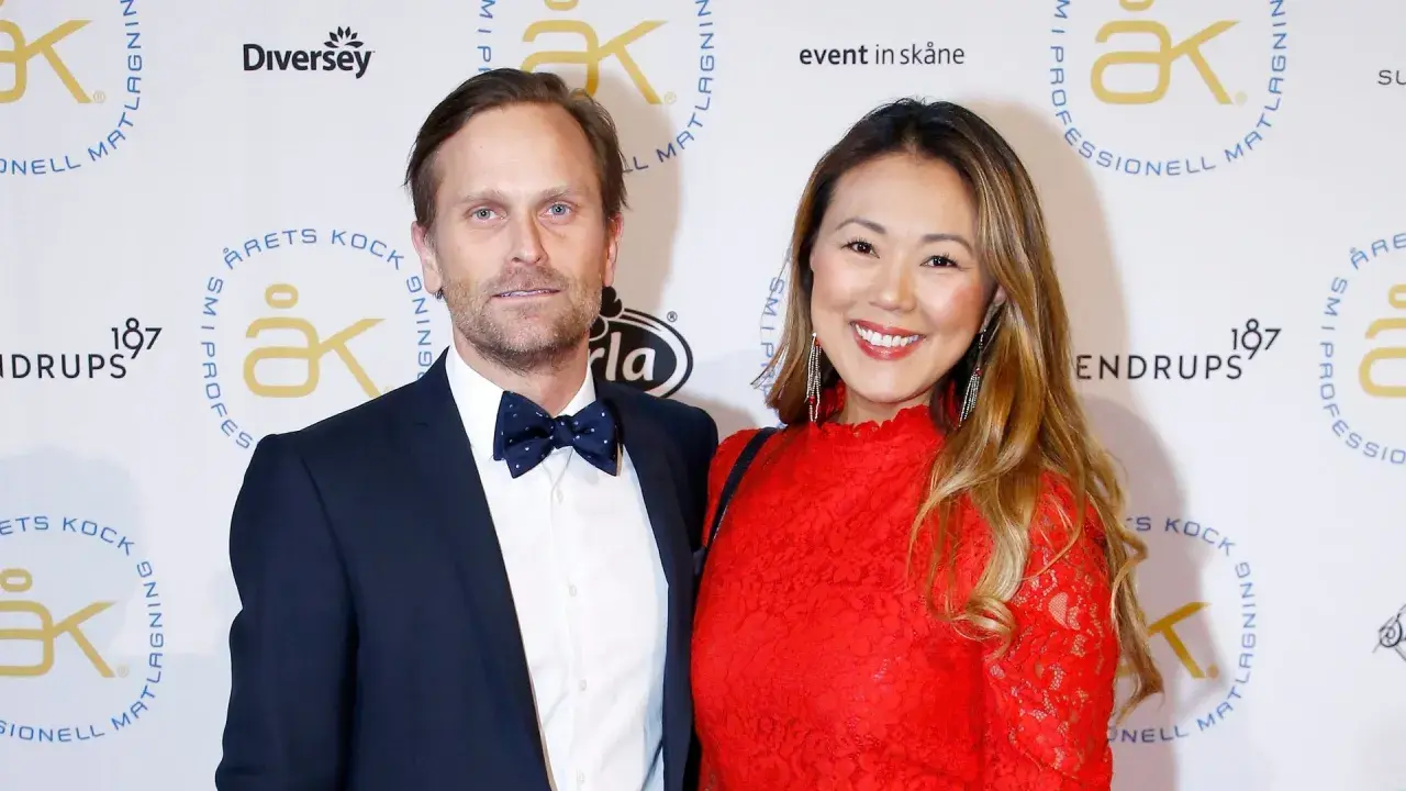 Jennie Wallden strålar i rött bredvid sin partner på en gala.