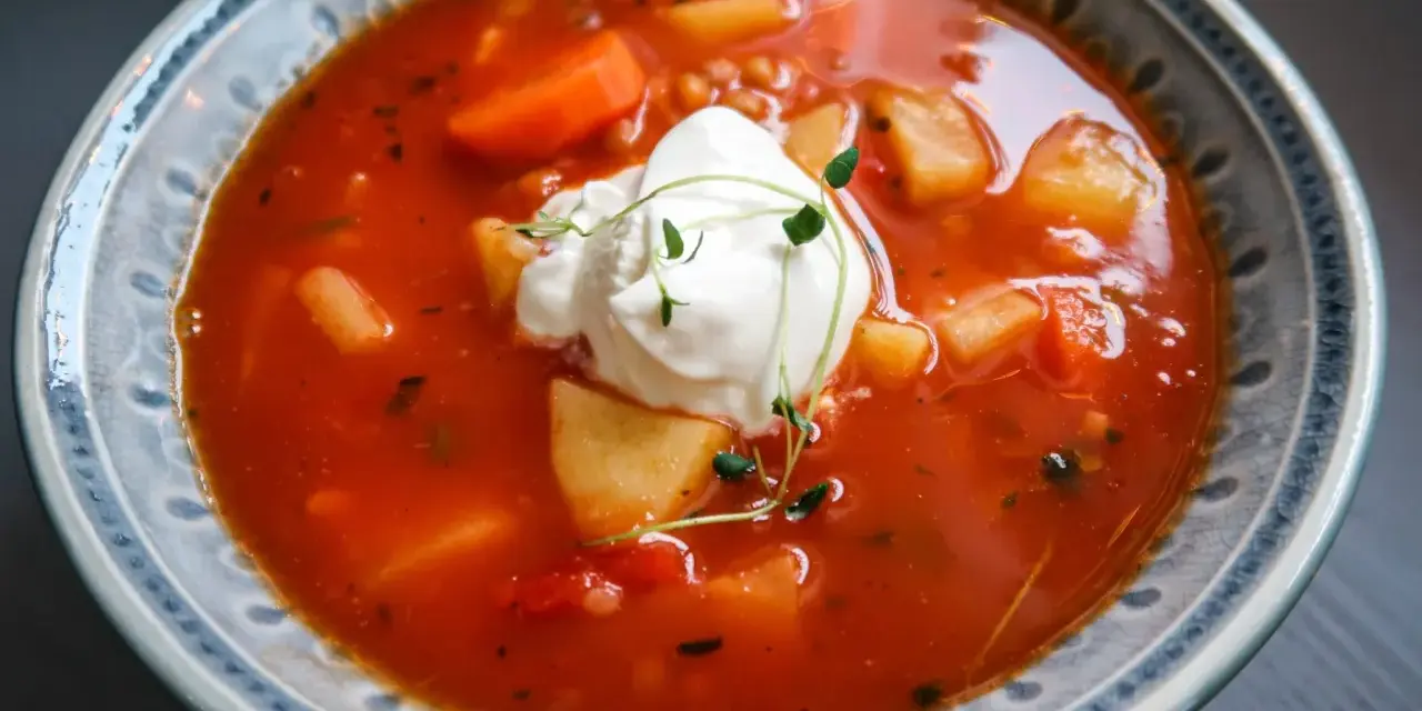 En värmande tomatsoppa med potatis, morötter och en klick krämig creme fraiche, toppad med färska örter.