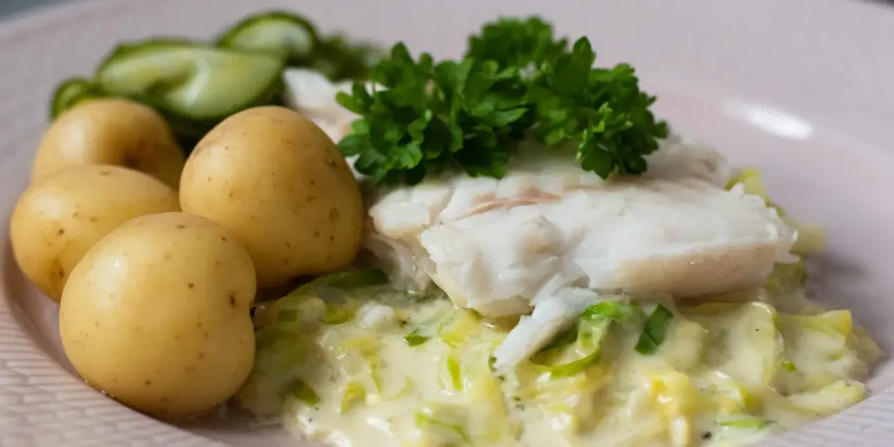 En portion stuvad spetskål med fisk, potatis och gurka. En klassisk svensk rätt som smakar ljuvligt.