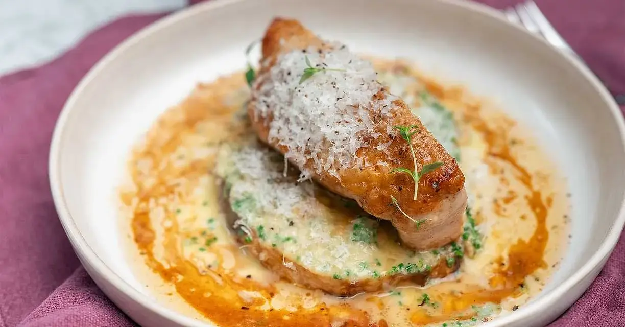 En saftig kycklingfilé toppad med parmesan och örter, serverad på en bädd av krämig grönsakspuré med en smakrik sås. Ett perfekt middagstips vardag!