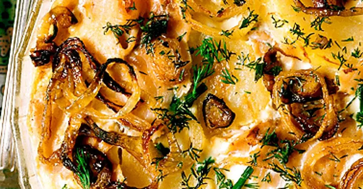 Laxpudding med gravad lax, potatis och karamelliserad lök, toppad med färsk dill. En klassisk svensk rätt.