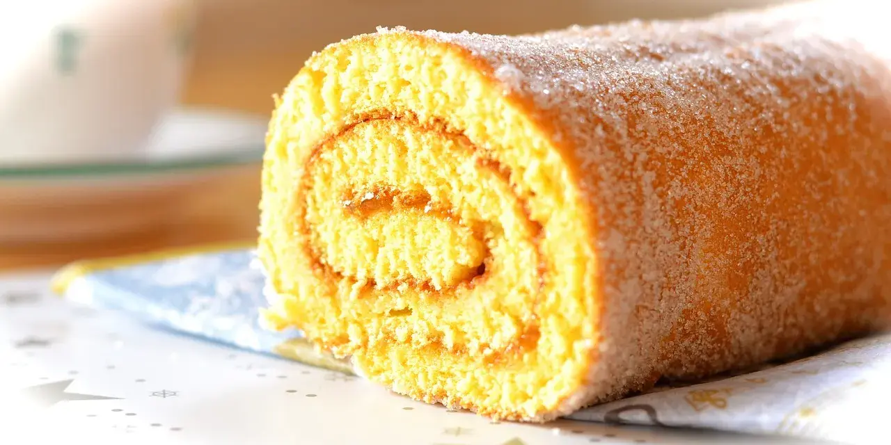 En saftig glutenfri rulltårta med sockerströssel, perfekt för fikat.