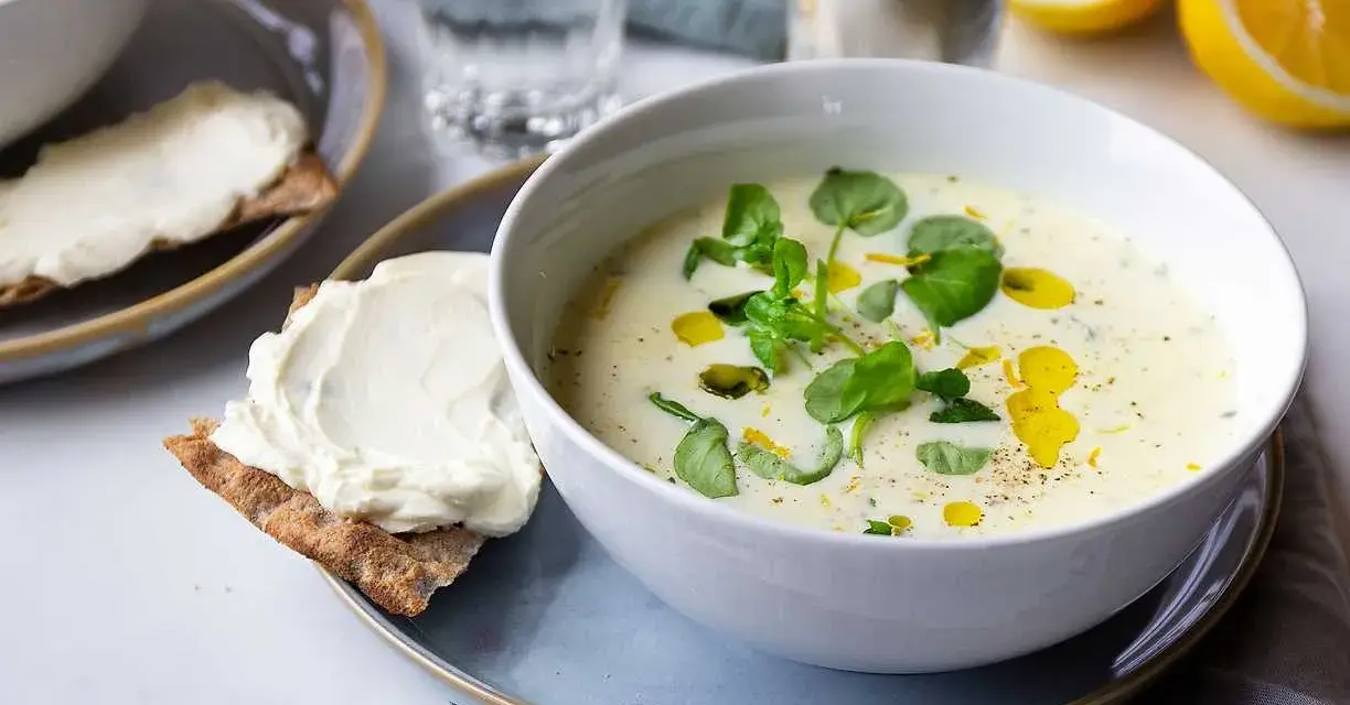 Krämig purjolökssoppa med färska örter och citron, serverad med knäckebröd och färskost.