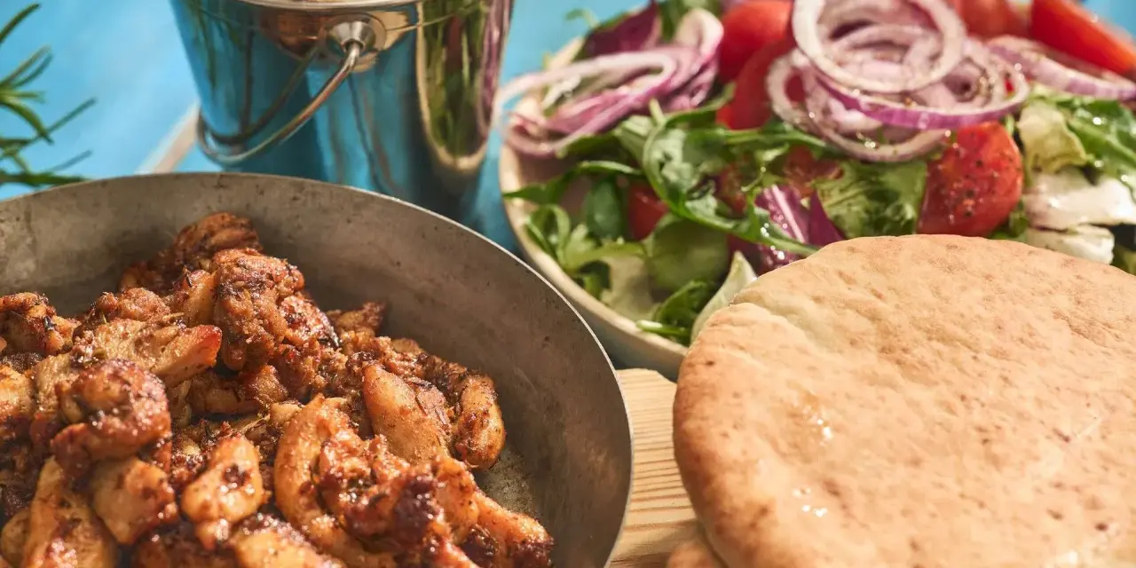En härlig grekland mat-upplevelse med saftigt kött, krispiga pommes, fräsch sallad och fluffigt pitabröd.
