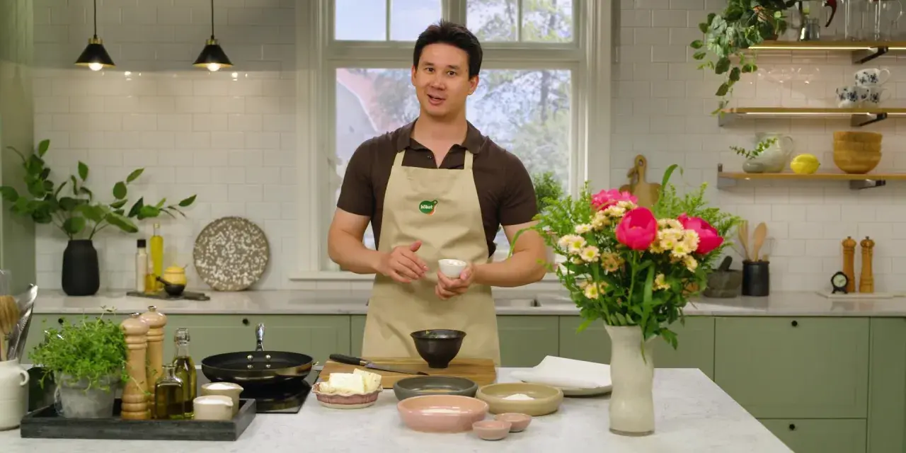 Filip Poon i köket, redo att laga mat med en bukett blommor bredvid.