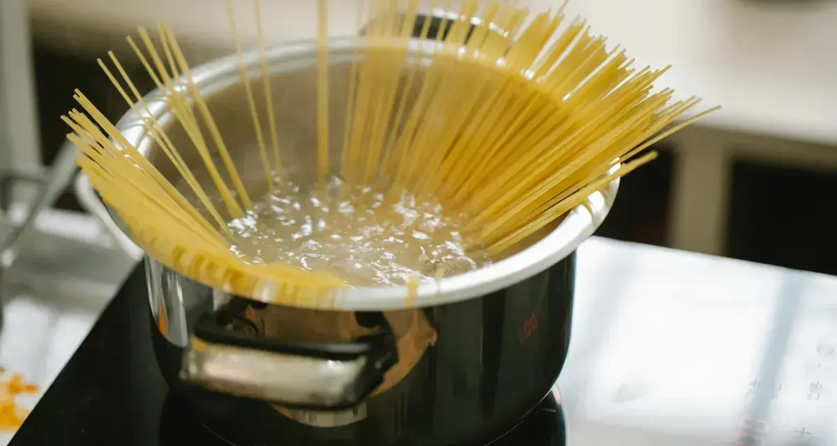 Spaghetti kokas i en kastrull på spisen. En perfekt mängd, för att veta hur mycket pasta per person som behövs.