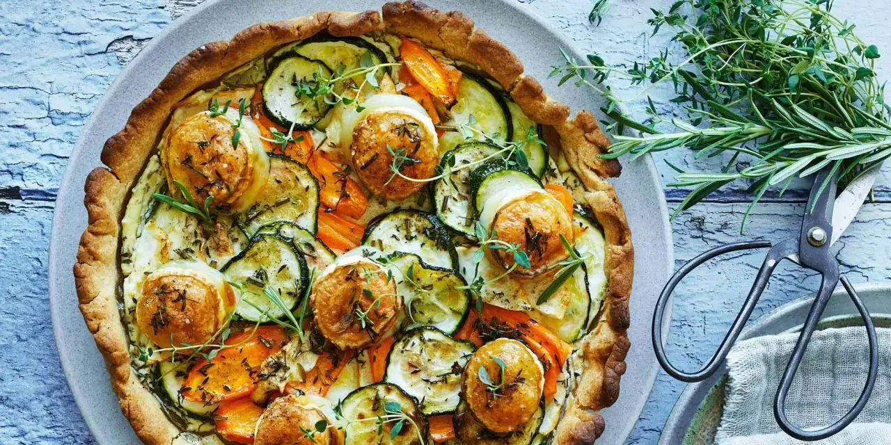 En gyllene, smakrik vegetarisk paj fylld med zucchini, morötter och toppad med ost. Garnerad med färska örter.