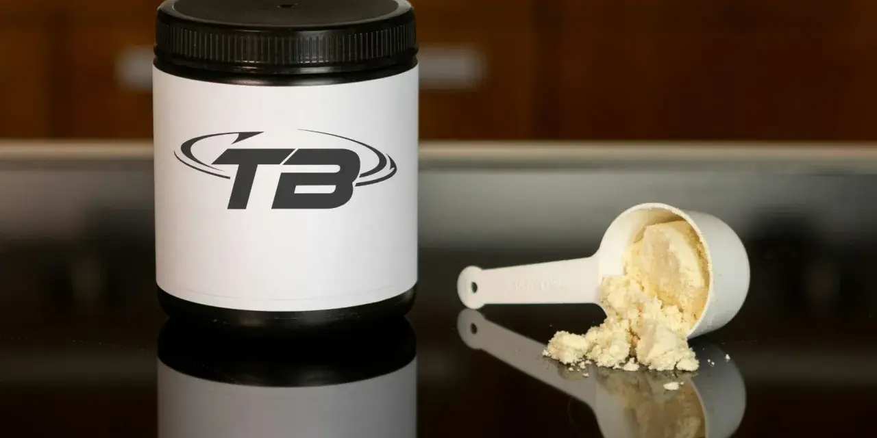 En burk med proteinpulver och en skopa med pulver. Perfekt för att veta hur mycket protein per dag du behöver.
