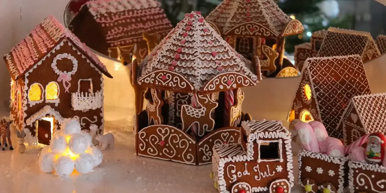 En hel by av pepparkakshus, med ett karusellhus i mitten och ett tåg som säger "God Jul".