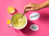 En hand lägger honung i en kopp te. Honung nyttigt för halsen, viskar pratbubblorna.