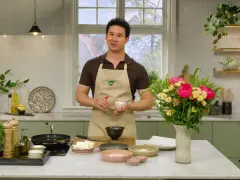Filip Poon i köket, redo att laga mat med en bukett blommor bredvid.