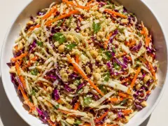 En fräsch asiatisk kålsallad med strimlad vit och rödkål, morötter, jordnötter och sesamfrön.