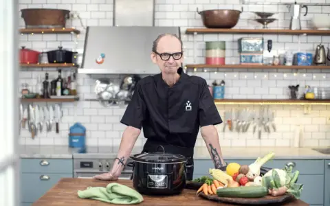 Erik Videgård i köket med en slow cooker och färska grönsaker.