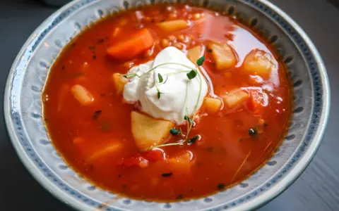 En värmande tomatsoppa med potatis, morötter och en klick krämig creme fraiche, toppad med färska örter.