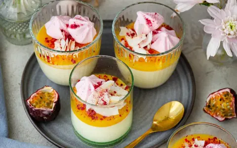 Vackra glas med en krämig påsk dessert, toppad med maräng, passionsfrukt och kokosflingor. En perfekt avslutning på påskfirandet.