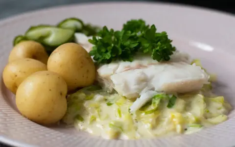 En portion stuvad spetskål med fisk, potatis och gurka. En klassisk svensk rätt som smakar ljuvligt.