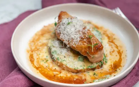 En saftig kycklingfilé toppad med parmesan och örter, serverad på en bädd av krämig grönsakspuré med en smakrik sås. Ett perfekt middagstips vardag!