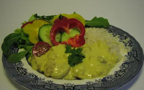 Enkel currysås över kyckling med ris och en fräsch sallad av paprika, gurka och tomat.