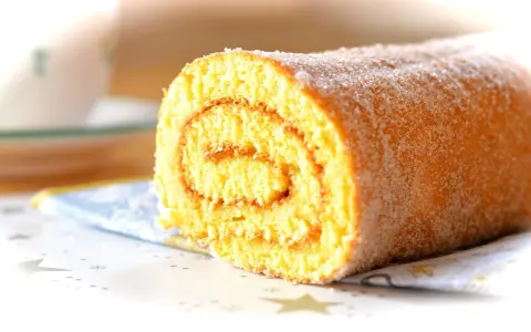 En saftig glutenfri rulltårta med sockerströssel, perfekt för fikat.