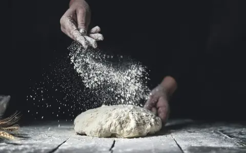 Händer strör mjöl över deg. En berättelse om svenskt bröd och kärleken till bakning med bra **bread flour svenska**.