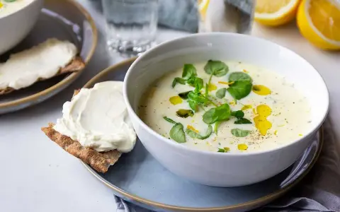 Krämig purjolökssoppa med färska örter och citron, serverad med knäckebröd och färskost.
