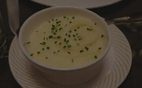 Krämig potatismos i en vit skål, garnerad med gräslök. Perfekt för att frysa potatis och njuta av senare.