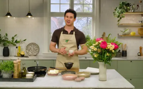 Filip Poon i köket, redo att laga mat med en bukett blommor bredvid.
