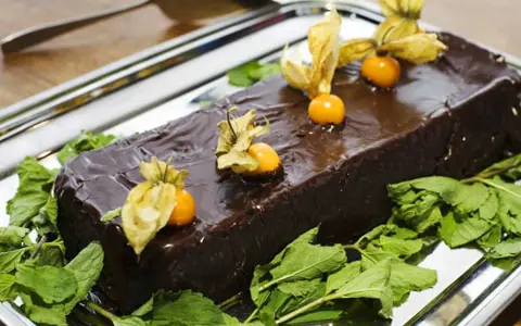 En glansig chokladtårta, perfekt för påsk, dekorerad med physalis och mynta. En härlig påsktårta choklad!
