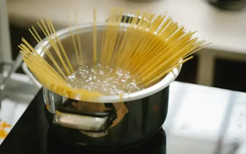 Spaghetti kokas i en kastrull på spisen. En perfekt mängd, för att veta hur mycket pasta per person som behövs.