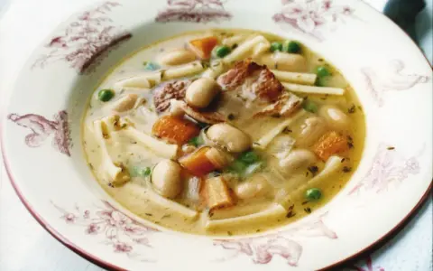 En skål med minestronesoppa med fläsk, bönor, morötter, ärtor och pasta.