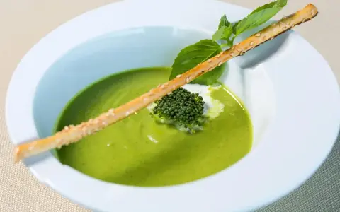 Grön ärtsoppa med en krispig brödpinnar och en liten broccoli-bukett. Perfekt för att se om man kan frysa ärtsoppa för framtida middagar.