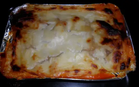 En ugnsbakad lasagne i aluminiumform, perfekt att frysa in lasagne för framtida middagar.