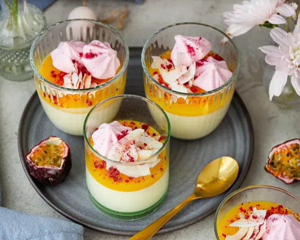 Vackra glas med en krämig påsk dessert, toppad med maräng, passionsfrukt och kokosflingor. En perfekt avslutning på påskfirandet.