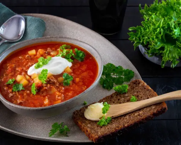 En värmande köttfärssoppa utan tomat, toppad med en klick gräddfil och färsk persilja. Serveras med grovt bröd och smör.
