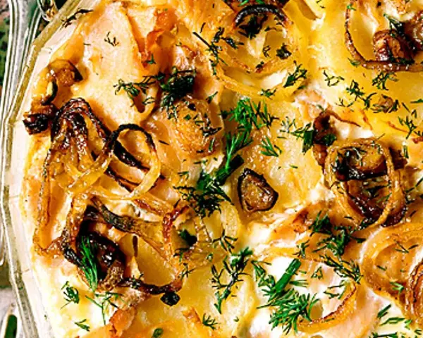 Laxpudding med gravad lax, potatis och karamelliserad lök, toppad med färsk dill. En klassisk svensk rätt.