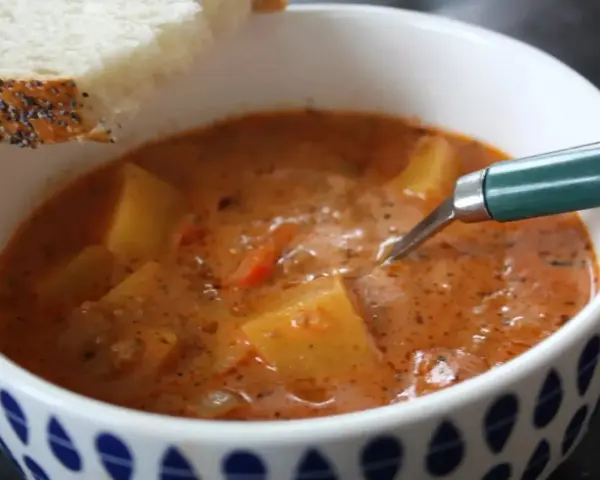 En värmande cowboy soppa med potatis och en bit bröd.