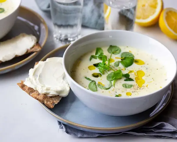 Krämig purjolökssoppa med färska örter och citron, serverad med knäckebröd och färskost.
