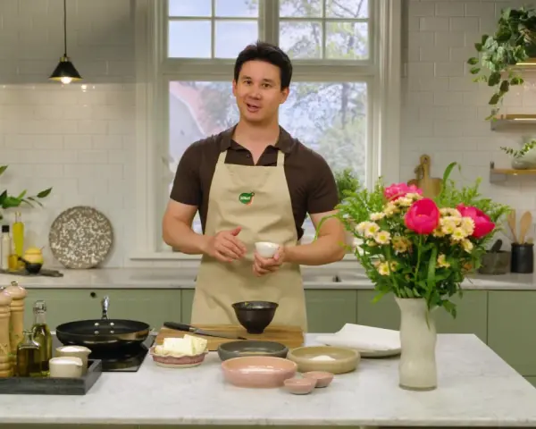 Filip Poon i köket, redo att laga mat med en bukett blommor bredvid.
